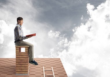 Elinde kırmızı kitap ile evin baca rahat oturan genç adam