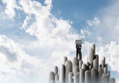 İşadamı kafasına silah tutmak yerine TV elbiseli güzel manzara ile taş sütunlar tepesinde dururken arka plan üzerinde çarpı işareti.