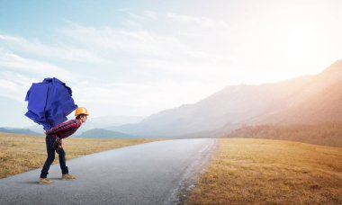 Sırtında kağıt top taşıyan inşaatçı.