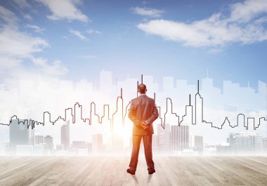 İşadamı arkasını dönüp modern iş merkezinin siluetine bakıyor.