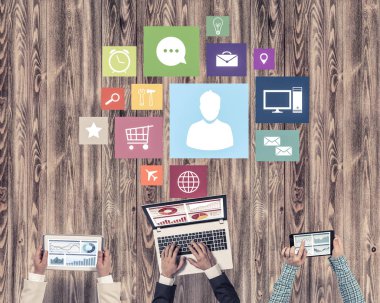 Ellerinde cihazlar bulunan üç kişilik bir grup iletişim ve ağ oluşturma sembolü olarak birlikte çalışıyor.