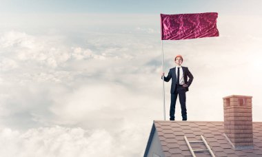 Çatıda duran ve elinde kırmızı bayrak tutan bir iş adamı. Karışık ortam