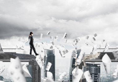 Kağıtları kocaman bir boşluk ile beton köprü üzerinde gizli tehditler ve riskler sembolü olarak uçan arasında blindfolded yürüyüş iş adamı. Cityscape görünümü arka plan üzerinde. 3D render.