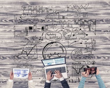 Ellerinde cihazlar bulunan üç kişilik bir grup iletişim ve ağ oluşturma sembolü olarak birlikte çalışıyor.