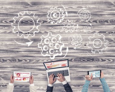 Ellerinde cihazlar bulunan üç kişilik bir grup iletişim ve ağ oluşturma sembolü olarak birlikte çalışıyor.