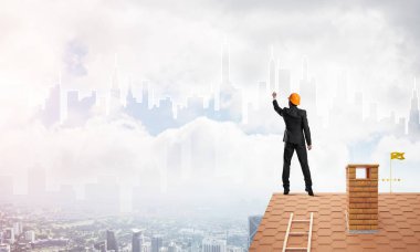 Mühendis, evinin çatısına geri döndü ve şehri çiziyor. Karışık ortam