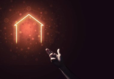 İnsanın eli parlayan ev simgesi ya da sembolüyle dokunuyor