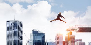 İş kadını zorlukların üstesinden sembolü olarak büyük boşluğu beton köprü üstünden atlayarak. Cityscape zemin üzerine güneş ışığı ile. 3D render.
