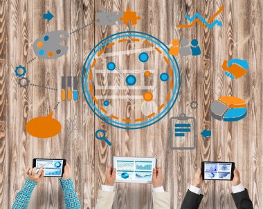 Ellerinde cihazlar bulunan üç kişilik bir grup iletişim ve ağ oluşturma sembolü olarak birlikte çalışıyor.