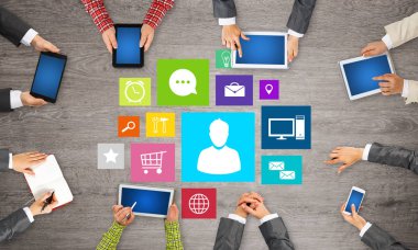 Ellerinde cihazlar bulunan bir grup insan, iletişim ve ağın sembolü olarak birlikte çalışıyor.