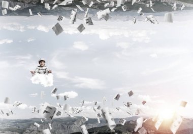 Genç küçük çocuk gözleri koruma kapalı ve seyir bulut kağıtları uçan arasında ve doğa dünyalar arasında üzerinde meditasyon sırasında konsantre.