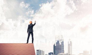 Mühendis, evinin çatısına geri döndü ve şehri çiziyor. Karışık ortam