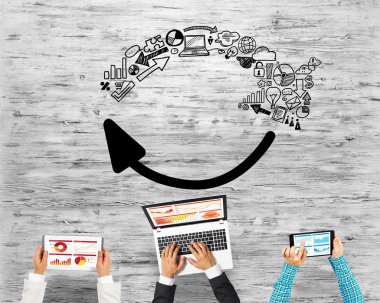 Ellerinde cihazlar bulunan bir grup insan, iletişim ve ağın sembolü olarak birlikte çalışıyor.