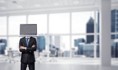 Baş ofis binası içinde dururken geçti silah tutmak yerine dizüstü bilgisayar ile takım elbiseli işadamı resim kırpılmış.