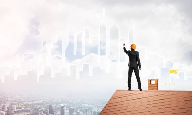 Mühendis, evinin çatısına geri döndü ve şehri çiziyor. Karışık ortam