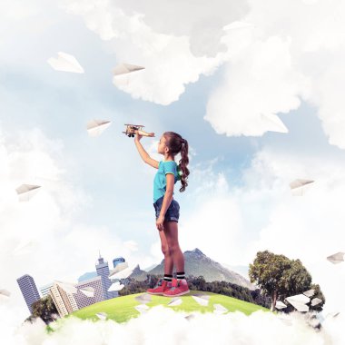 Şehrin yüzen adasında eski model uçaklarla oynayan tatlı bir kız.