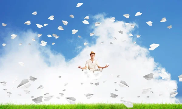 若い男の目を維持が閉じられ 雲の背景に明るく美しい風景と紙飛行機を飛行中に瞑想しながら集中して見て — ストック写真