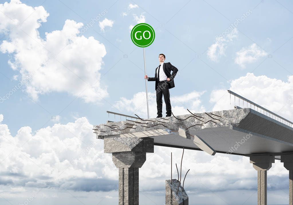 Confident businessman in suit holding green go sign while standing on broken bridge with skyscape on background. 3D rendering.
