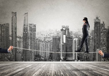 İp üzerinde yürüyen gözleri olan bir iş adamı.