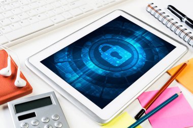 Ofis eşyalarıyla iş yeri ve ekranda asma kilit simgesi olan tablet