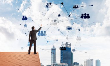 Delikanlı çatıda dikiliyor ve bağlantı hatları çiziyor. Karışık ortam