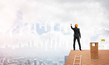 Mühendis, evinin çatısına geri döndü ve şehri çiziyor. Karışık ortam