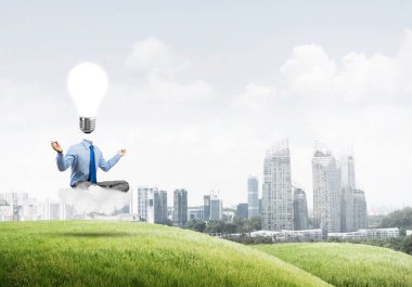 Nilüfer çiçeği pozu ve ampulde oturan bir iş adamı.