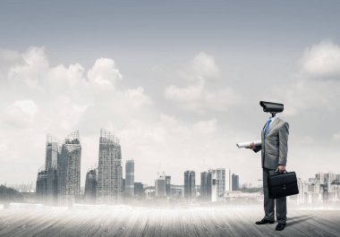 Şehir planına kafa atmak yerine kamerayla zum yapan yüzsüz bir iş adamı.