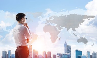 Çenesinde elleri olan genç ve zarif bir iş adamı başka tarafa bakıyor.