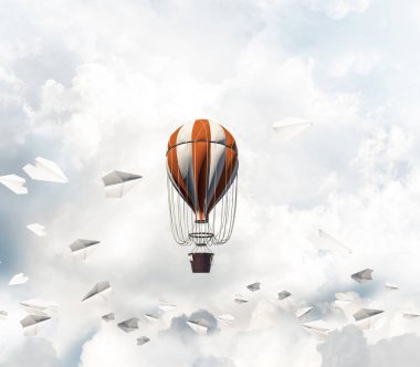Kağıt uçakların arasında ve mavi bulutlu gökyüzünde renkli bir aerostat uçuyor. 3B görüntüleme.