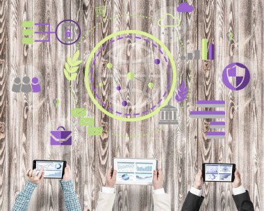 Ellerinde cihazlar bulunan üç kişilik bir grup iletişim ve ağ oluşturma sembolü olarak birlikte çalışıyor.