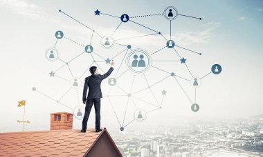 Delikanlı çatıda dikiliyor ve bağlantı hatları çiziyor. Karışık ortam