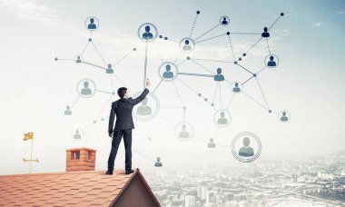 Delikanlı çatıda dikiliyor ve bağlantı hatları çiziyor. Karışık ortam