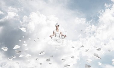 Kadın beyaz giyim gözler tutmak kapalı ve seyir kağıt uçaklar hava bulutlu gökyüzü ile arka plan üzerinde uçan arasında meditasyon sırasında konsantre.