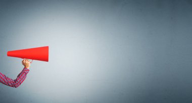 Bir kadının kâğıt borazanla anons yapması.