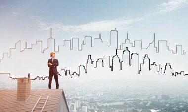 Takım elbiseli genç işadamı ve çatıda kask var. Karışık ortam