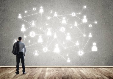 Arkadan görünüşü çizilmiş sosyal bağlantı kavramı ile duvara bakarak işadamı