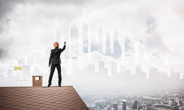 Mühendis, evinin çatısına geri döndü ve şehri çiziyor. Karışık ortam