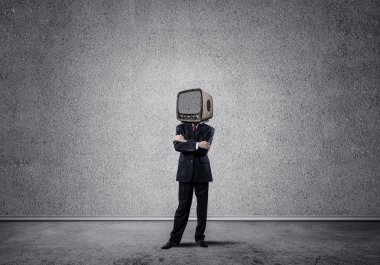 Arka plan üzerinde duran gri Duvar ile boş oda içinde iş başına silah tutmak yerine eski bir Tv ile takım elbiseli adamı geçti.