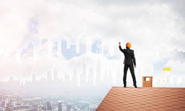 Mühendis, evinin çatısına geri döndü ve şehri çiziyor. Karışık ortam