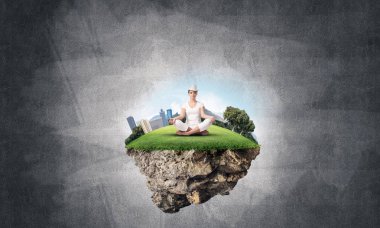 Kadın beyaz giyim gözler tutmak kapalı ve seyir arka plan üzerinde Adası gri karanlık Duvar ile havadaki uçan üzerinde meditasyon sırasında konsantre.