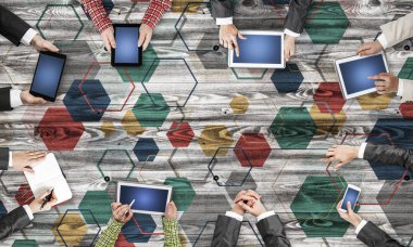 Ellerinde cihazlar bulunan bir grup insan, iletişim ve ağın sembolü olarak birlikte çalışıyor.