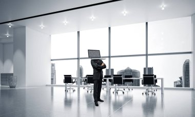 İş dizüstü bilgisayar kafasına silah tutmak yerine ile takım elbiseli adamı dururken ofis binası içinde geçti. 3D render.