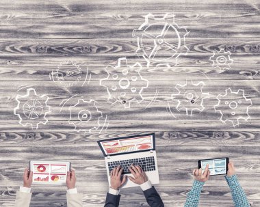 Ellerinde cihazlar bulunan üç kişilik bir grup iletişim ve ağ oluşturma sembolü olarak birlikte çalışıyor.