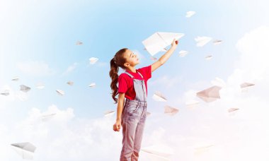 Kağıt Uçak ile oynarken gökyüzü arka plan karşı küçük şirin kız