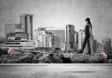 İp üzerinde yürüyen gözleri olan bir iş adamı.