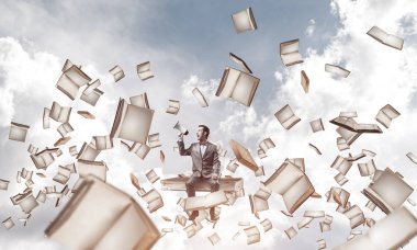 Kitap üzerinde oturan ve duygusal megafon içinde çığlık genç işadamı