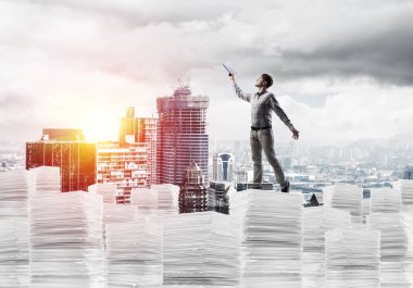 Rahat kıyafet ise cityscape belgelerle yığını üzerinde duran ve arka plan üzerinde güneş ışığı el kitabı ile uydurarak erkekte yan görünüm. Karışık teknik.