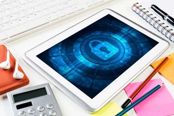 Ofis eşyalarıyla iş yeri ve ekranda asma kilit simgesi olan tablet