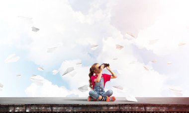 Dürbünle bakan, okul çağındaki sevimli kız çatıyı inşa ediyor.